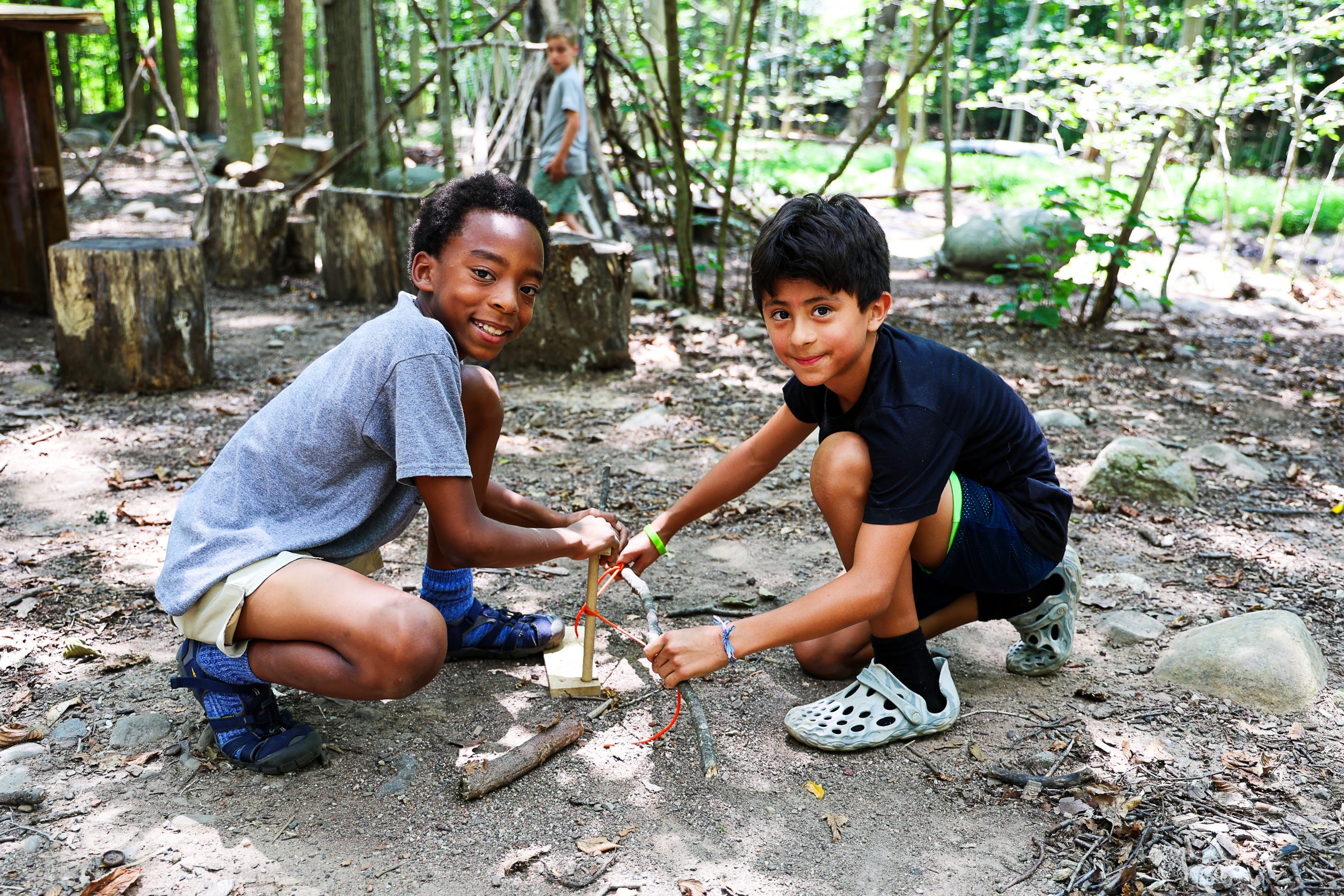 Young campers in the woods learning outdoor skills; nature immersion at The Nature Place Day Camp