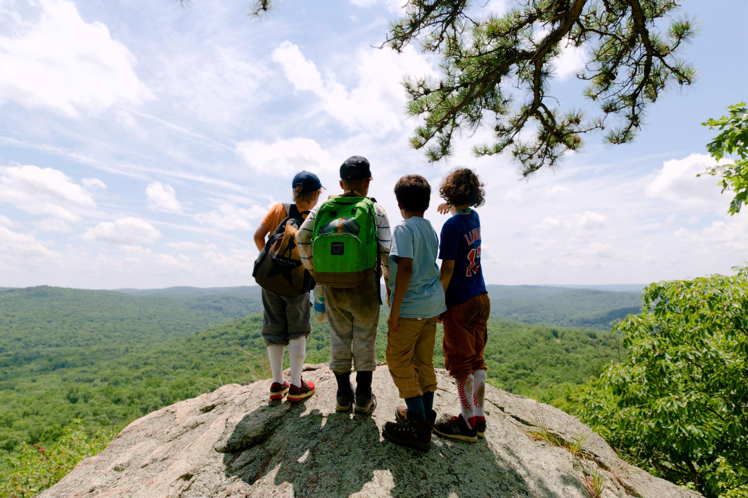 Campers on the summit of a hike with blue sky and hills in the distant background as part of The Nature Place mission to provide screen-free summer activities for kids in the NY Metro area